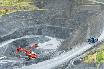 Open pit quarry, dump truck carrying gravel: construction industry