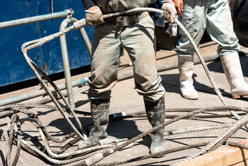 Construction worker handling sling wire, construction sites