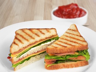 Delicious toasted sandwiches with cheddar cheese and bacon on the plate