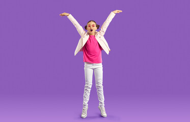 Overjoyed teen girl child isolated on violet studio background have fun jumping and laughing....