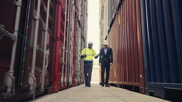 Low level angle Foreman and inspector checking container box for quality control of logistic export and import in docker.