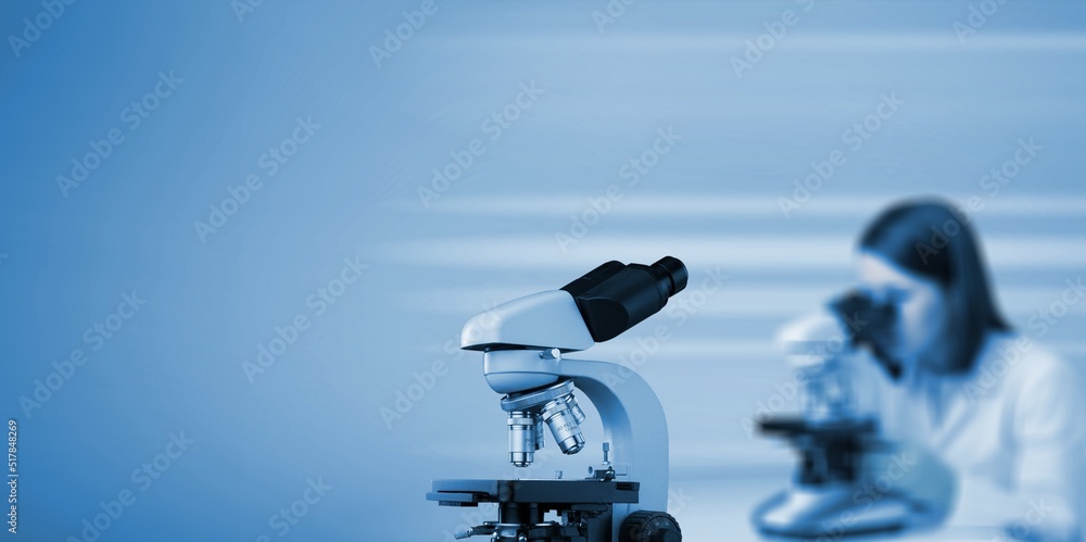 Poster professional laboratory microscope and scientists working in the background