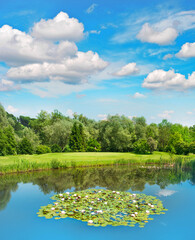 Fototapeta premium Golf course green field lake blue sky European landscape