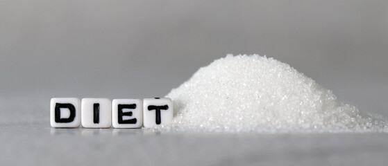 White cube arranged in the word  ’DIET' with sugar. The concept of reducing sugar intake.

