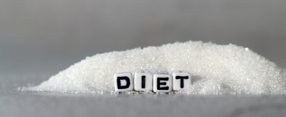 White cube arranged in the word  ’DIET' with sugar. The concept of reducing sugar intake.
