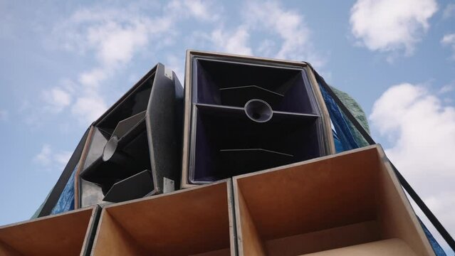Huge festival speaker stack showing top horns and bass bins. slow motion rotation for cinematic style.