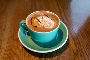 Cup of cappuccino on a wooden table close-up view