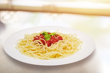 spaghetti pasta in a white plate with ketchup sauce