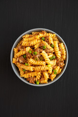 Homemade One-Pot Cheeseburger Pasta in a Bowl on a black background, top view. Flat lay, overhead, from above.