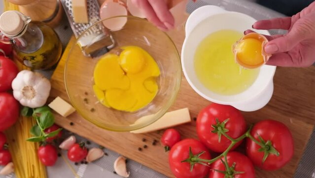 making pasta carbonara - pouring crushed egg yolk into glass bowl