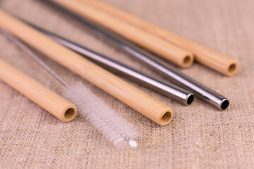Bamboo and metal reusable straws on a natural linen background. Ecological bamboo straws. Say no to plastic.
