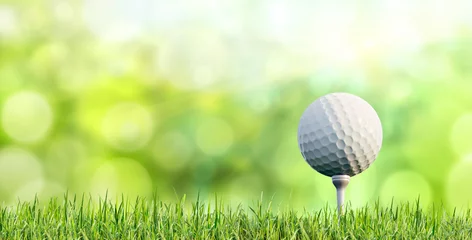 Poster Golf ball on tee with grass and green blurred background - 3D Illustration © peterschreiber.media