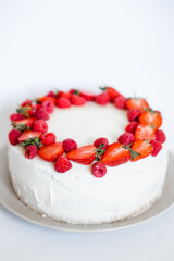 Delicious biscuit cake with cream cheese and berries. Light cake with strawberries and raspberries. Top view. Copy space background