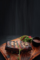 Grilled ribs with sauce on a wooden board
