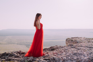 A girl in a red dress on the background of the mountains lifestyle. Illustrating articles about...