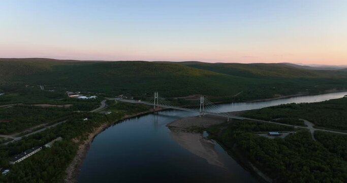 Aerial view of the Sami Bridge and Teno river, midnight sun in Utsjoki, Finland - Ascending, drone shot