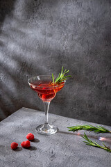 Summer refreshing alcoholic cocktail. Raspberry lemonade garnished with fresh rosemary. Summer raspberry beverage with sparkling water.  Copy space.