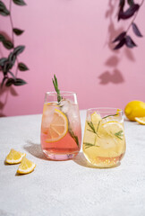 Summer refreshing non-alcoholic cocktails. Lemonade garnished with fresh rosemary. Summer beverage with sparkling water and lemon slices.