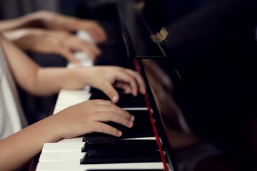 Choose to focus on the boy's fingers and the piano key teacher to play the piano. There are musical...