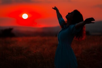 Woman in the field with flowers on sunset background