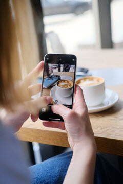 Close up of female hand's taking photo of coffee cup