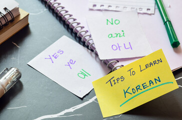 Concept of learning Korean language. Hand written flash cards with Korean basics and translation. Selective focus.