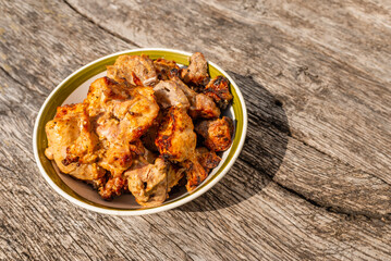 Shashlik grilled meat bbq in the bowl on the old gray oak table outdoors.Copy space.Closeup.