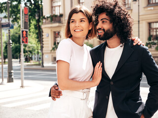 Smiling beautiful woman and her handsome boyfriend. Sexy cheerful multiracial family having tender moments in the street at sunset. Multiethnic models hugging. Embracing each other.Love concept