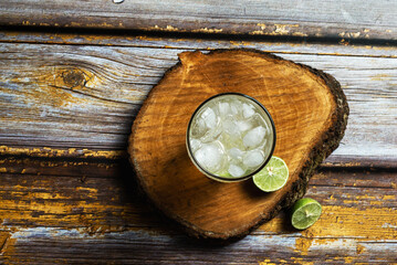 Glass of cold lemonade on wooden table. Ice cold drink.
