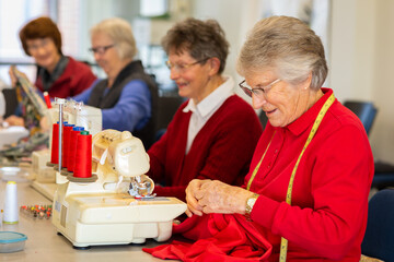 group of older ladies sewing with machines