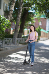 middle aged woman with a backpack rides a scooter around the city on a summer day