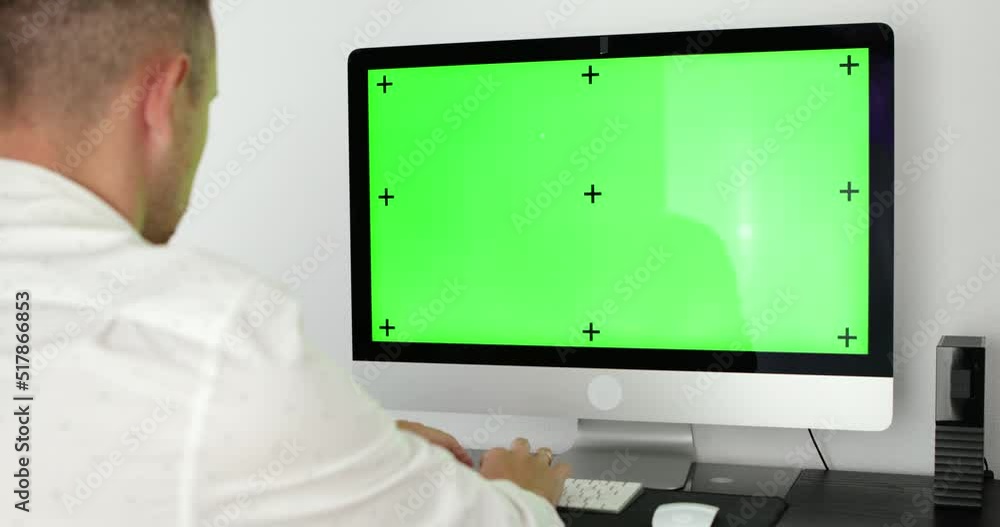 Poster green screen. employee working at computer sitting at desk. view from back.