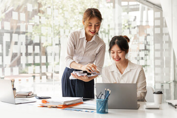 Fototapeta premium Business Asian discussing in modern office, small group asian female sale team staff smart solving plan data graph chart result job report talk on desk table at office.