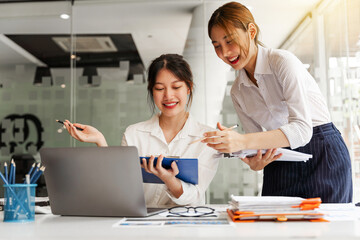 Business Asian discussing in modern office, small group asian female sale team staff smart solving plan data graph chart result job report talk on desk table at office.