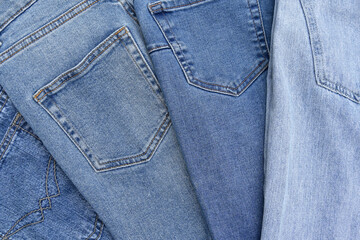 Fototapeta premium Lots of jeans pants in a stack. Denim background.