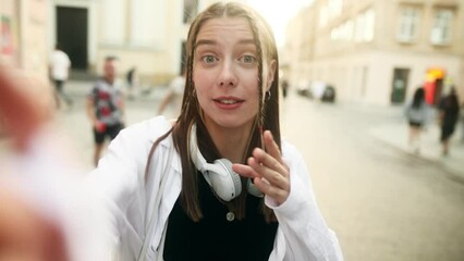 Portrait of cheerful young woman looking at camera and talking recording vlog.  POV of cute young lady making online video call looking at camera.