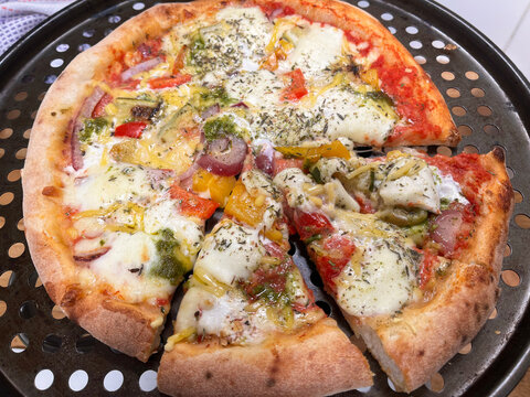 Vegetarian Pizza with Pesto, Peppers Red Onion and Mozzarella.