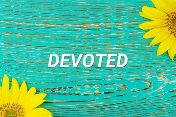 DEVOTED - text, yellow flowers, sunflowers, wooden background (copy space).