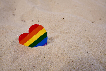 Rainbow heart made of paper lies on the sand. LGBT flag. LGBTQIA Pride Month in June. Lesbian Gay...