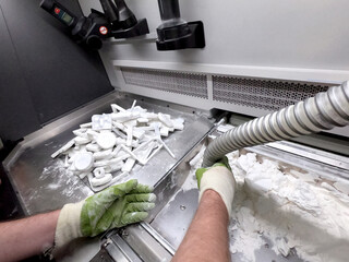 Engineer or artist designer printing 3D parts and shaping models from dust 3D print. Sculpting,...