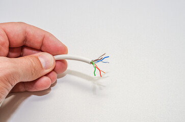 A computer wizard strips the wires of an Internet cable for connecting a twisted pair cable to a...