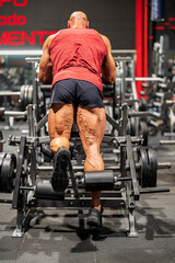 Fototapeta na wymiar Bodybuilder exercising leg muscles on gym machine