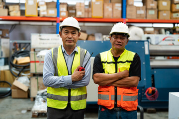 Factory worker foreman and engineer manager working together at warehouse.