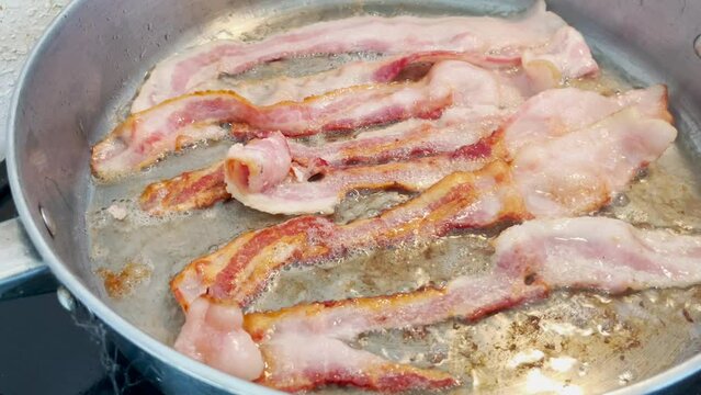 Bacon Sizzling in hot skillet. Close-up.