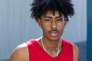 head and shoulders of young man with a mop of black hair looking intently into the camera