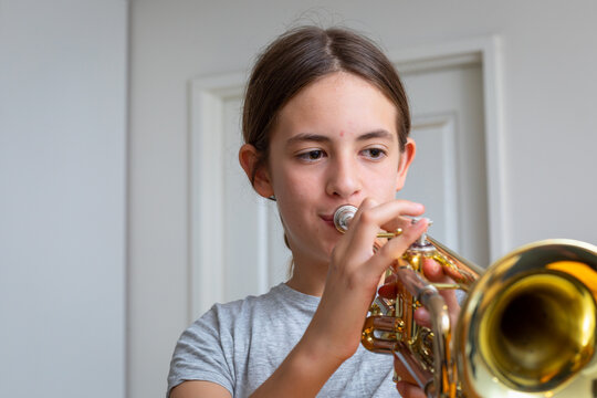 young girl practising her trumpet at home