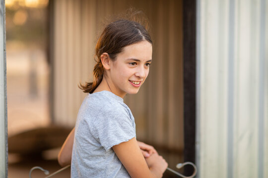 neutral colour photo of girl by herself at shed gate
