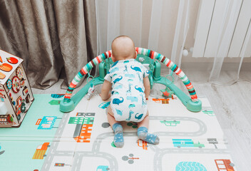 Above angle shot of adorable Baby boy lying on child friendly floor puzzle mats looking up