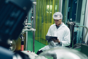 Scientist holding paper board and checking rotational vaporizer during CBD oil extraction, hemp oil...