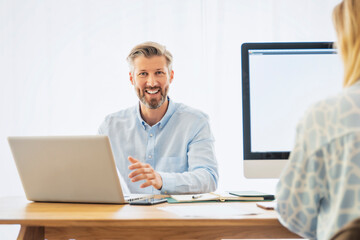 Handsome businessman using a computer while sitting at desk and working from home